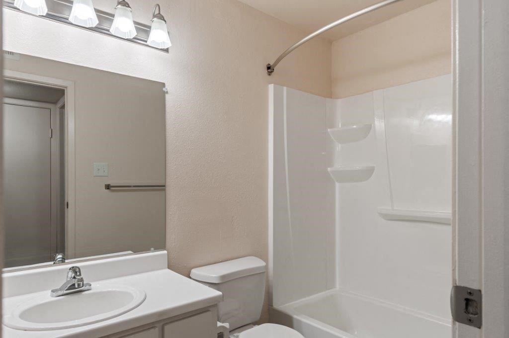 a bathroom with a sink toilet and a mirror