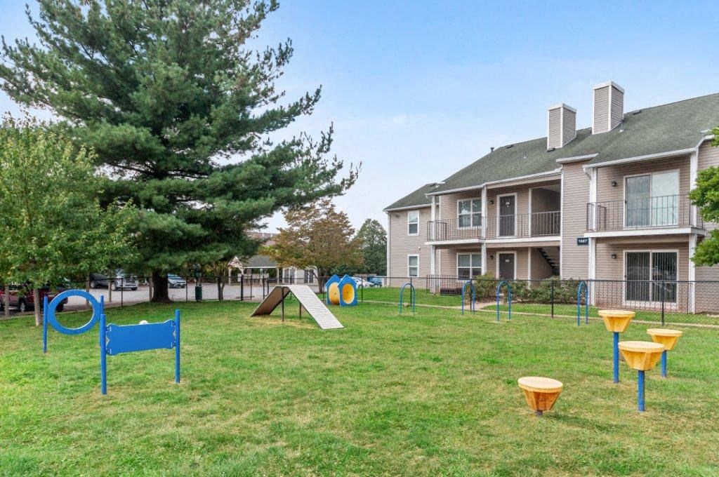 a playground in a yard in front of an apartment building