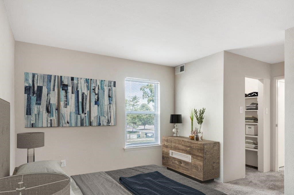 a bedroom with a dresser and a painting on the wall