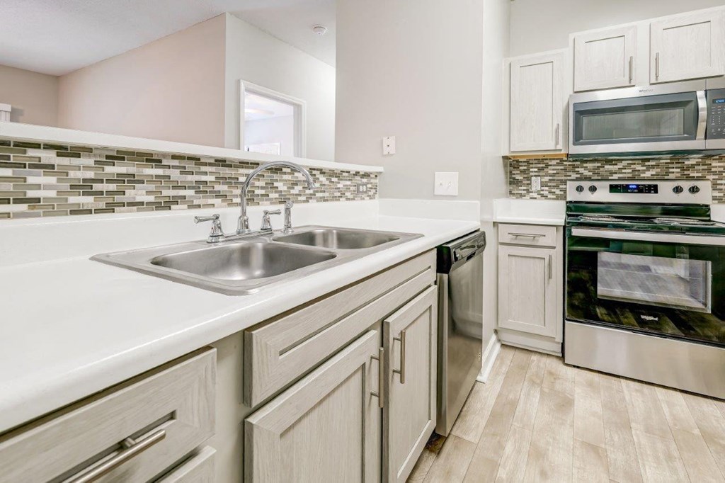 a kitchen with a sink and a stove and a microwave