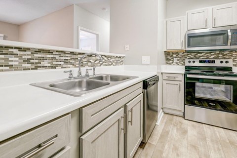 a kitchen with a sink and a stove and a microwave