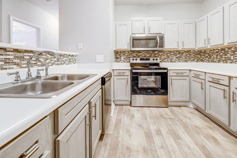 a kitchen with white cabinets and stainless steel appliances