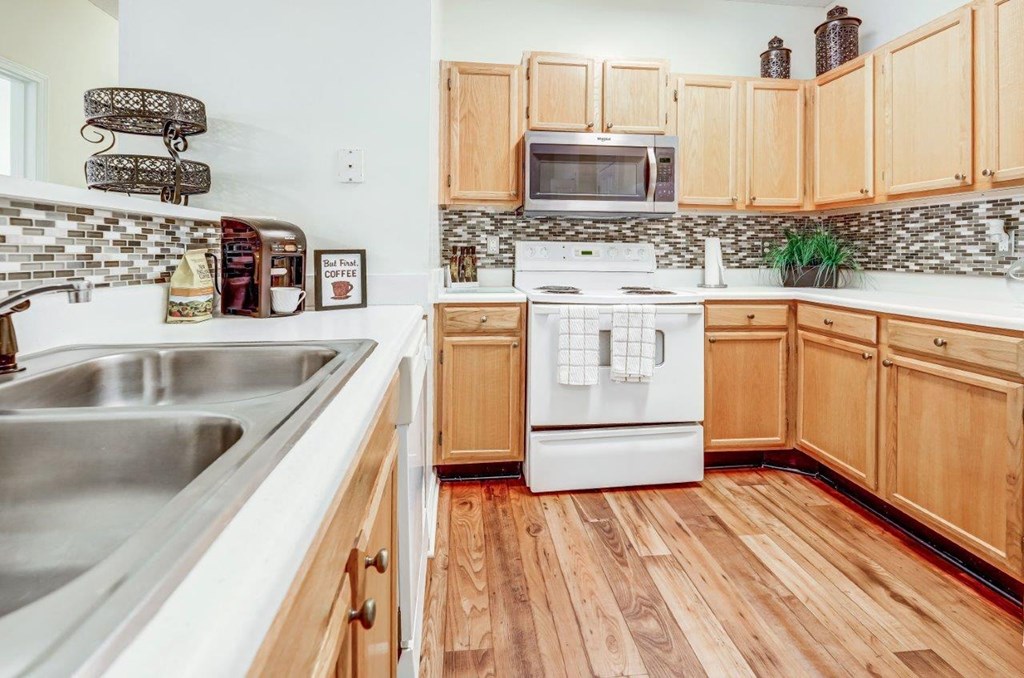 a kitchen with white appliances and wooden cabinets