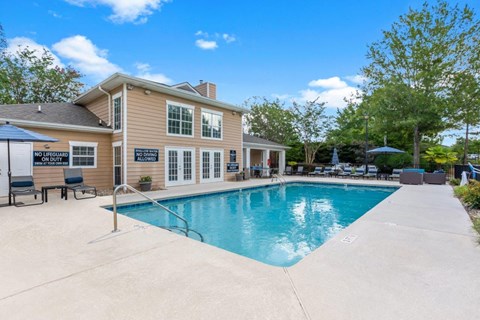 a swimming pool with a house in the background