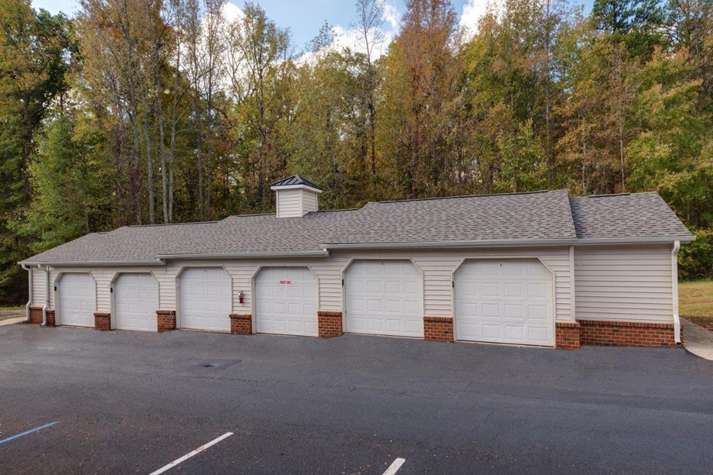 a large white garage with brick pillars and a roof