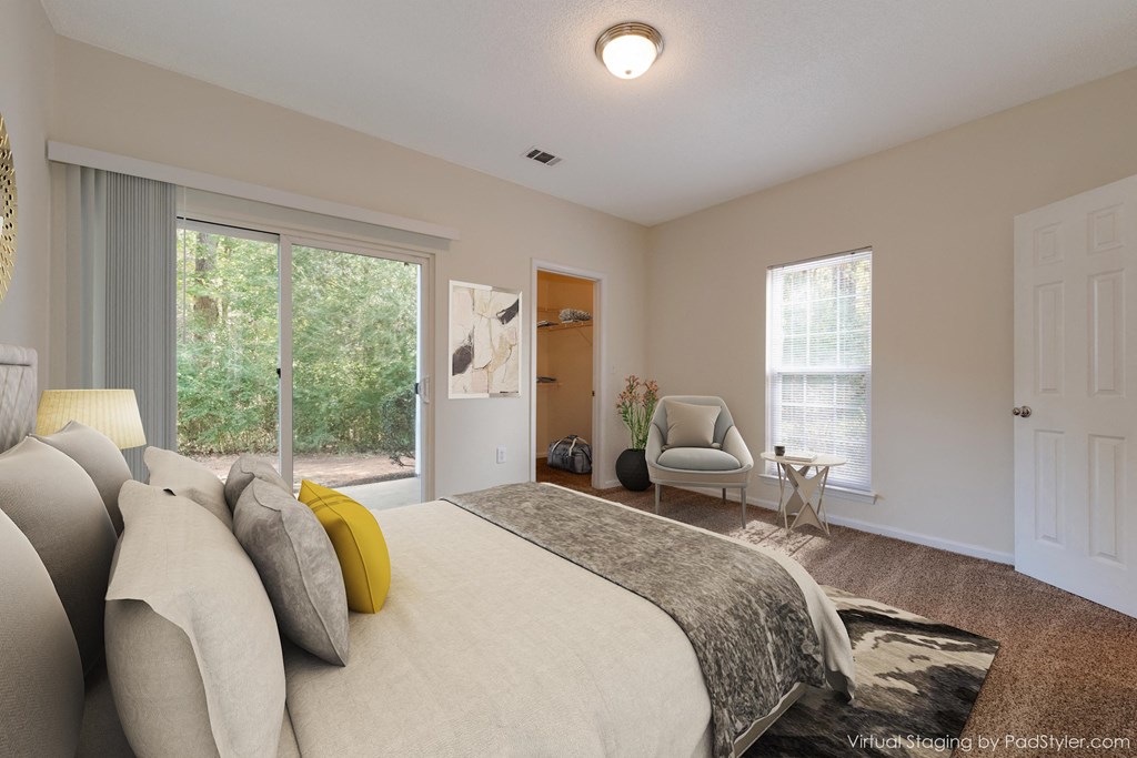 a bedroom with a large bed and a chair and a window