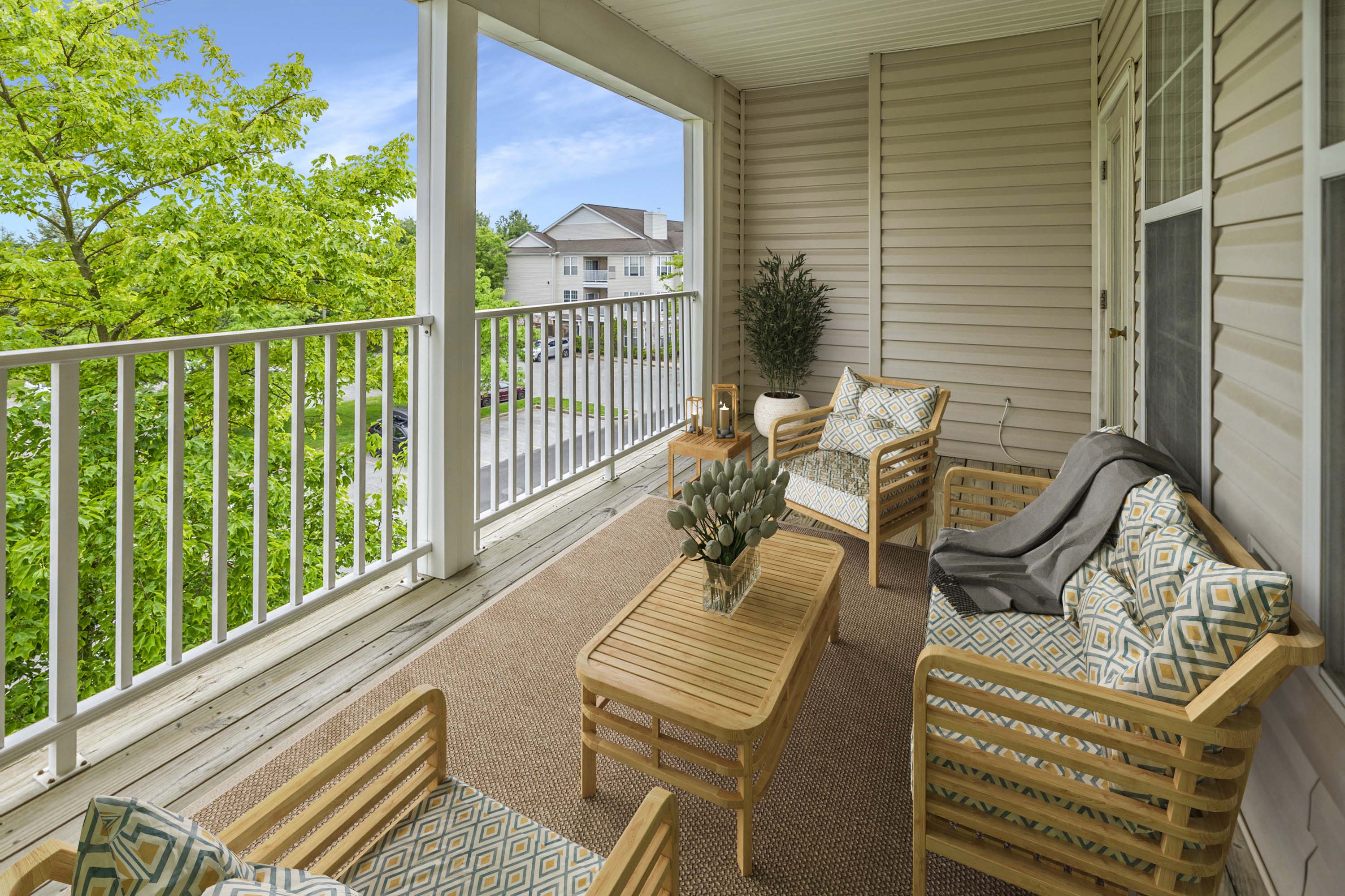 a covered porch with chairs and a table