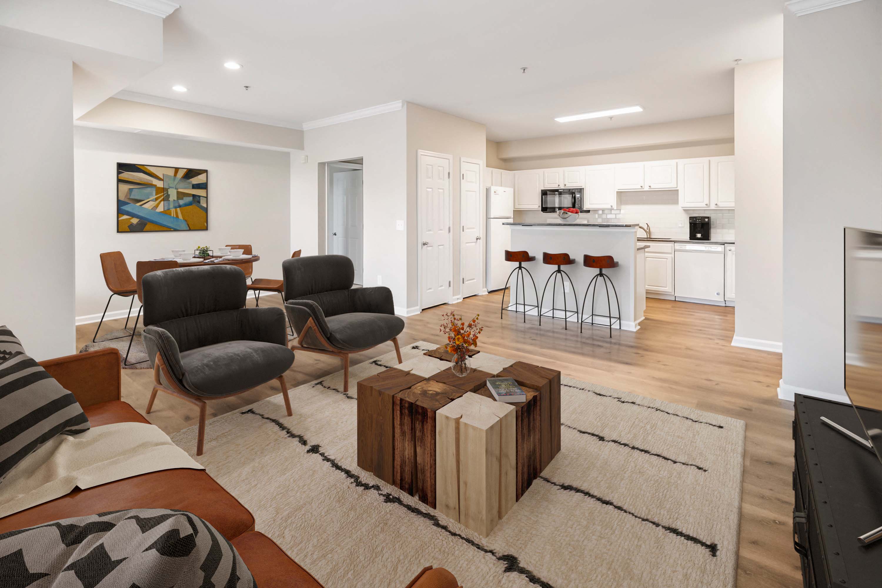 a living room with a couch and a table in front of a kitchen