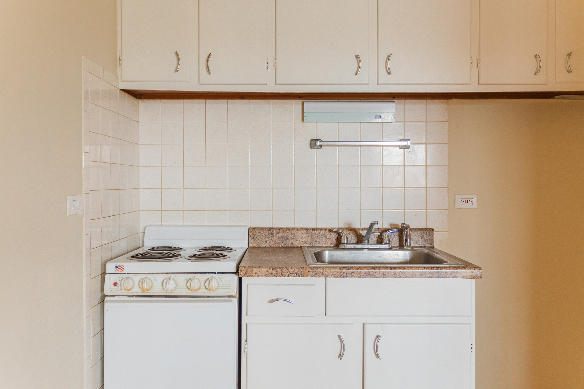 an empty kitchen with white appliances and white cabinets