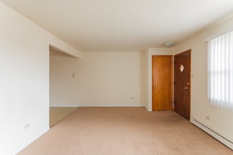 a bedroom with a carpeted floor and a wooden door