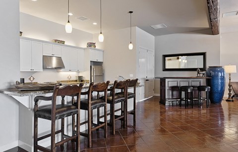 a kitchen with a bar with chairs and a table