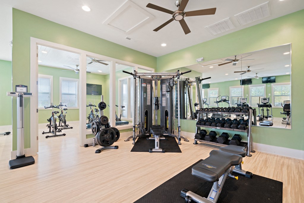 a home gym with weights and a ceiling fan
