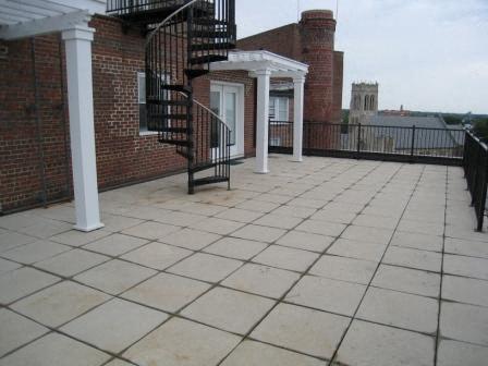 a balcony with a spiral staircase and a brick building