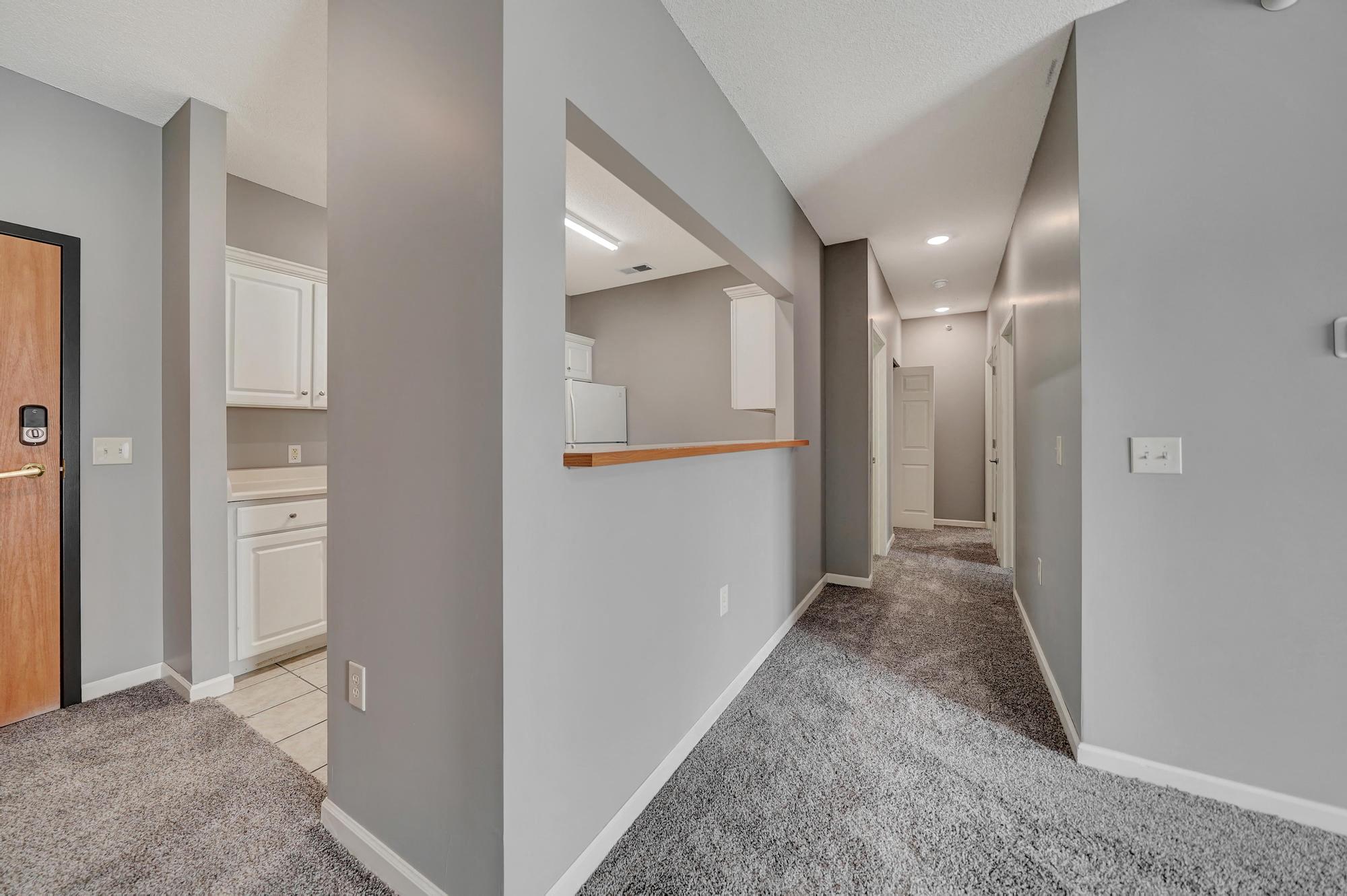 a renovated living room with a hallway to a kitchen