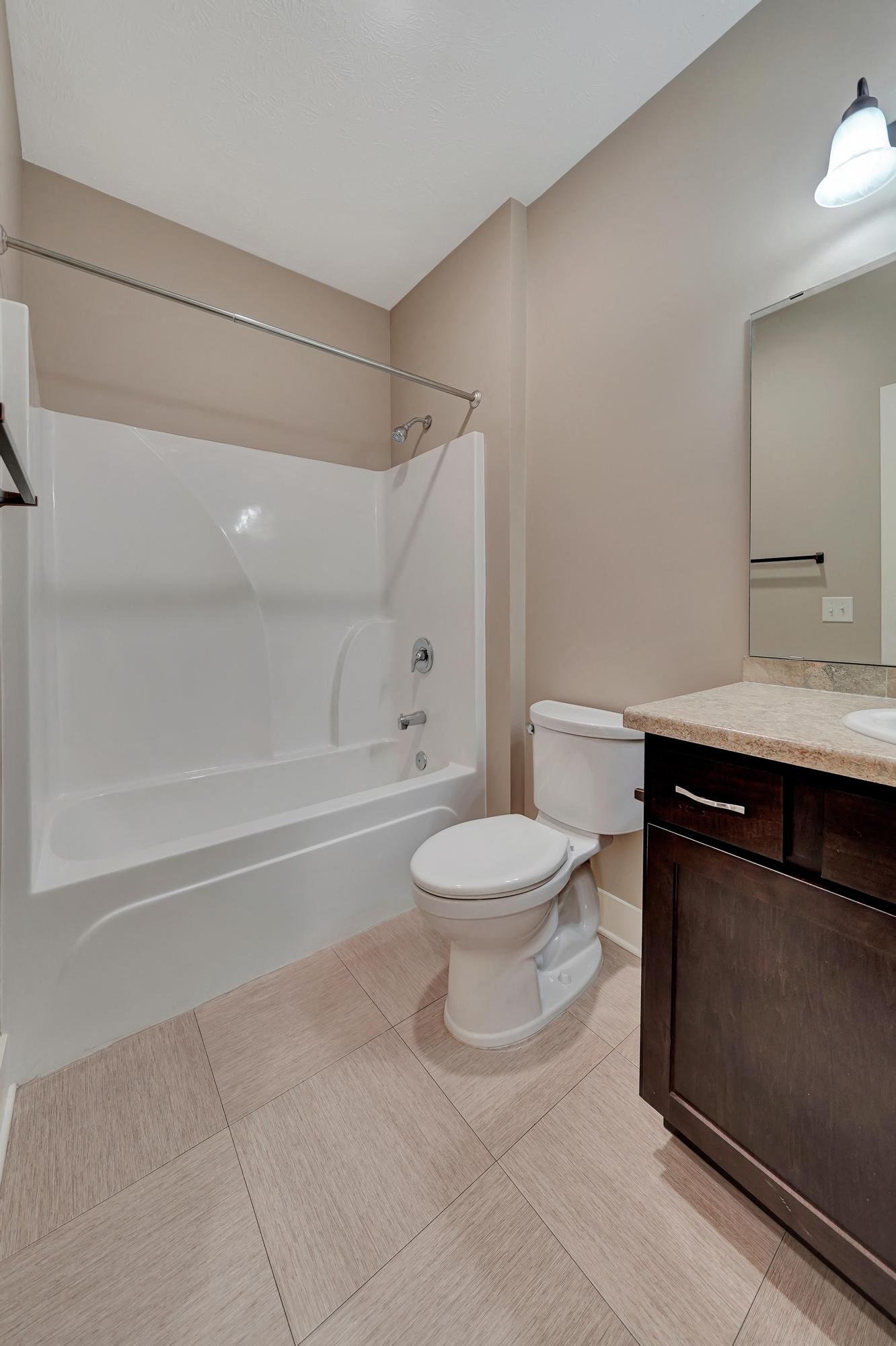 a bathroom with a toilet and a tub and a sink