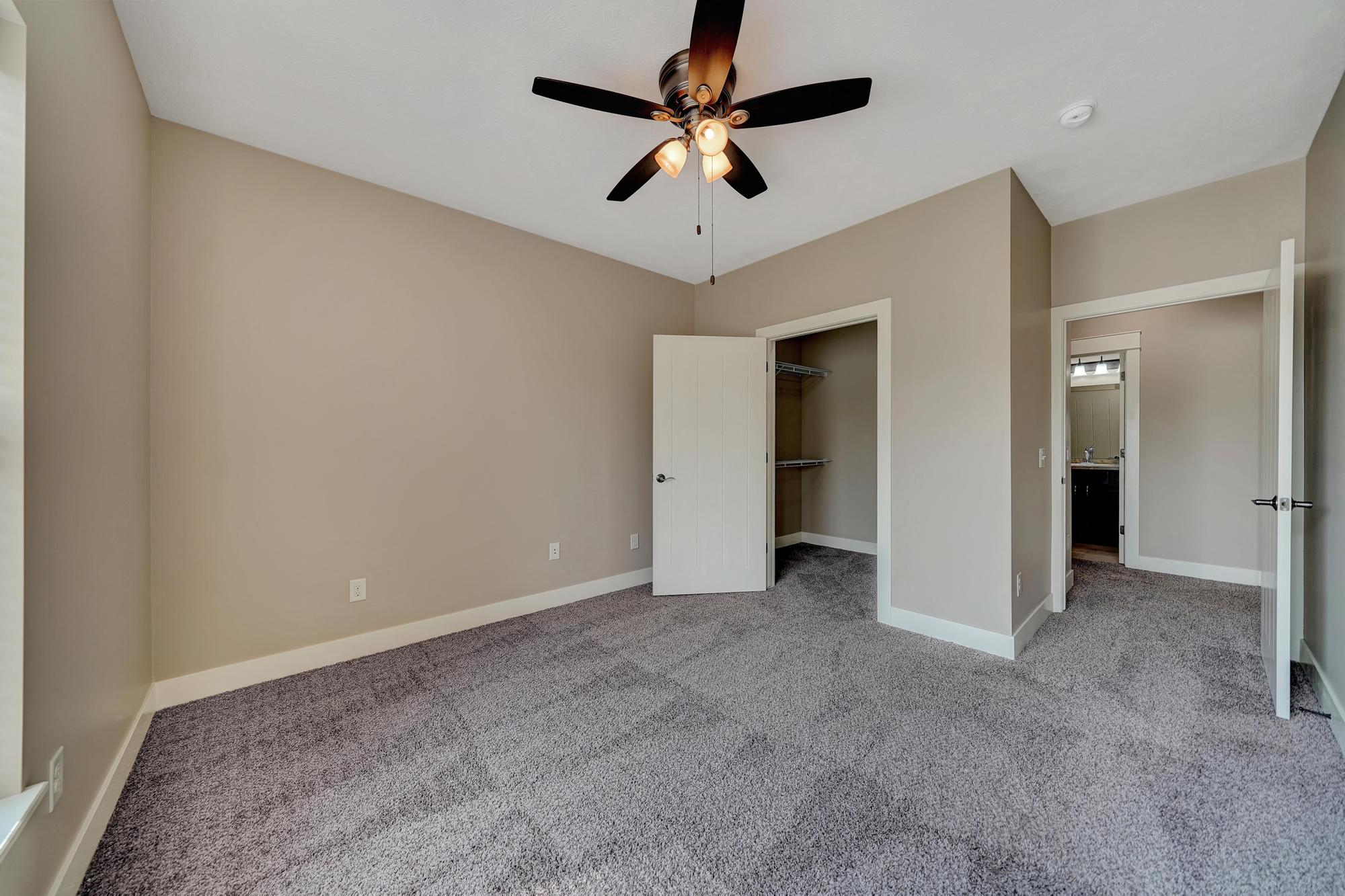 an empty living room with a ceiling fan
