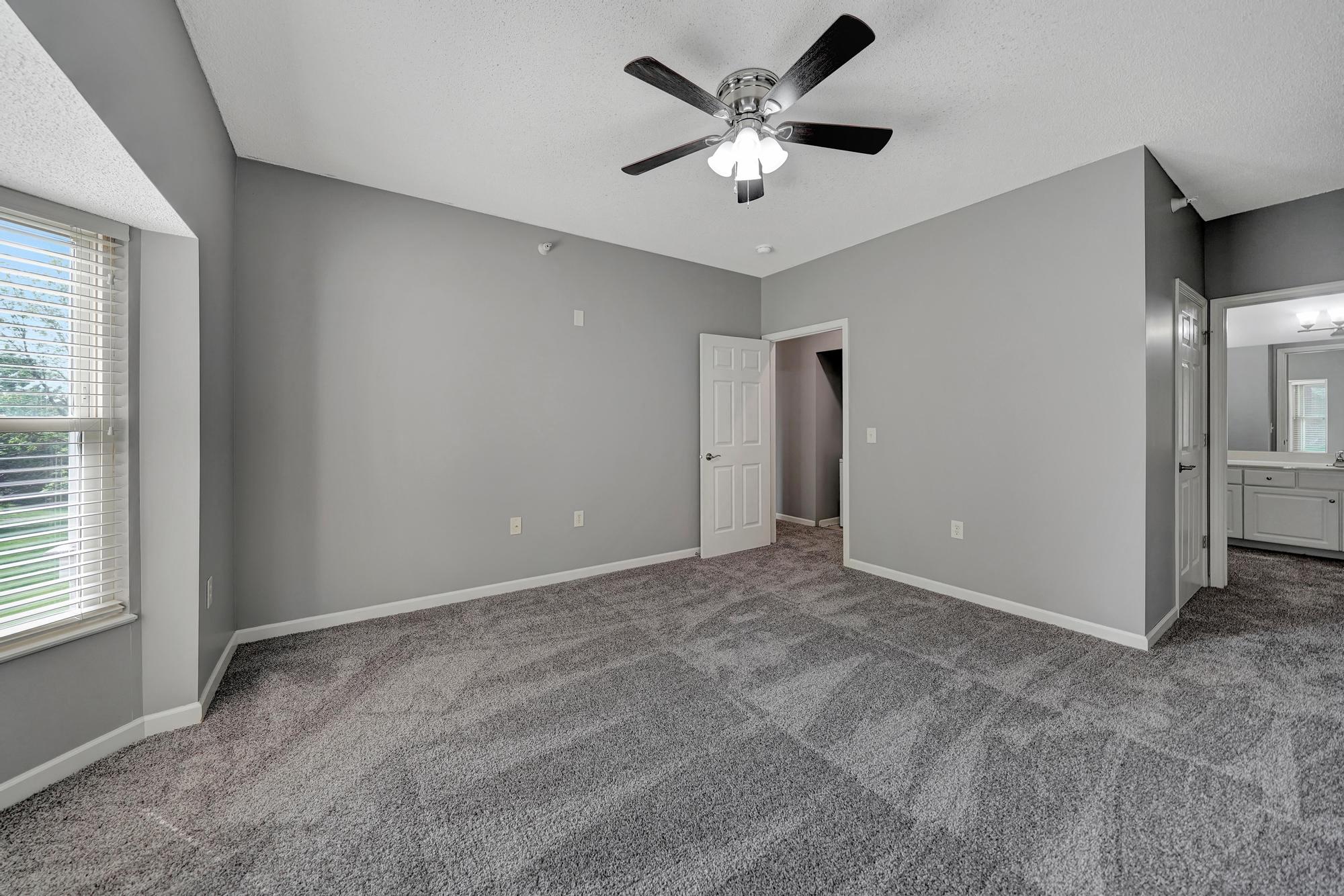 the living room of a new home with a ceiling fan