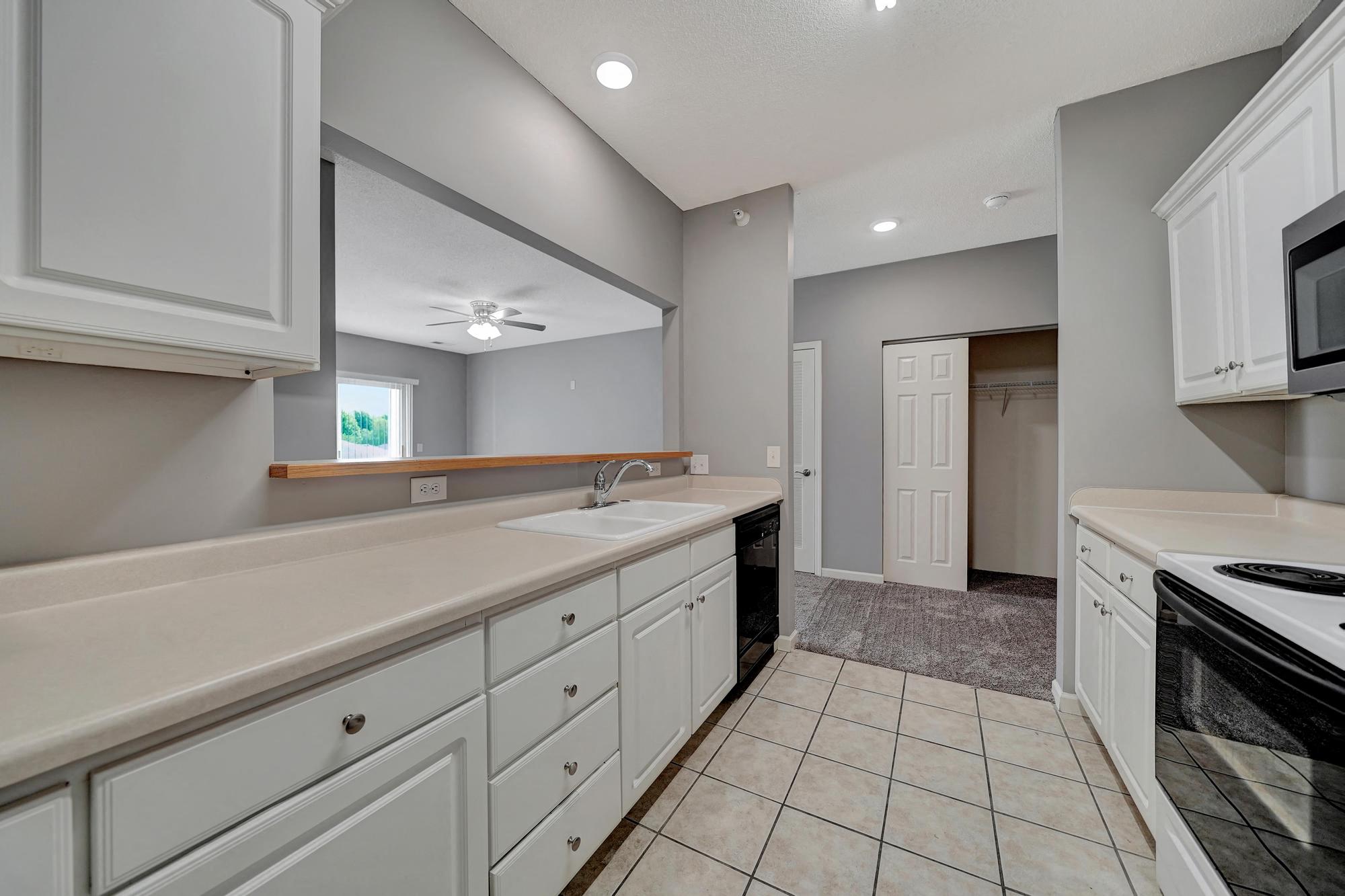a kitchen with white cabinets and a sink and a microwave