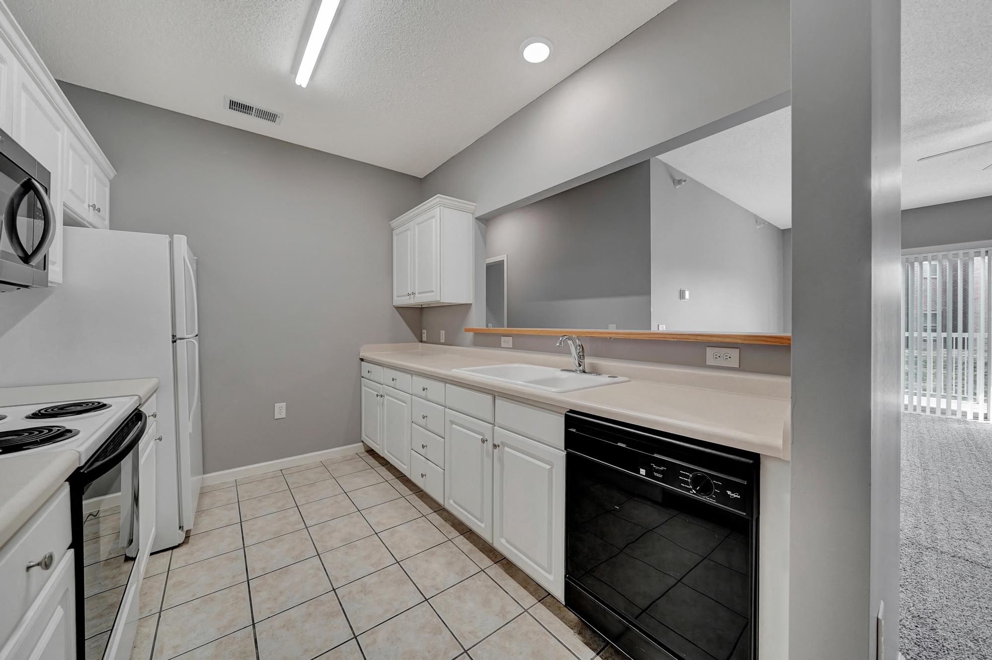 a kitchen with white cabinets and a sink and a refrigerator