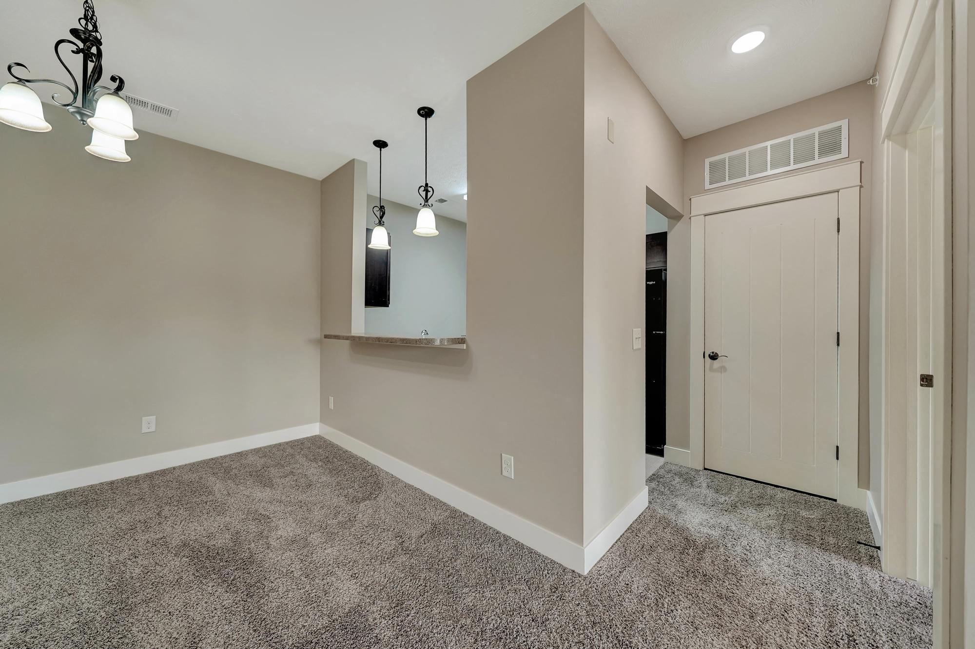 an empty living room with a door to a closet