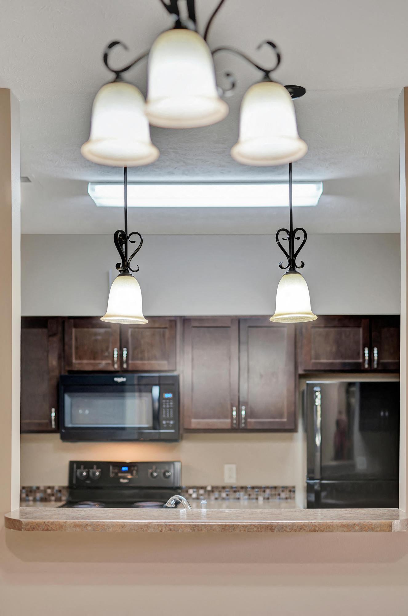a kitchen with three lamps hanging from the ceiling