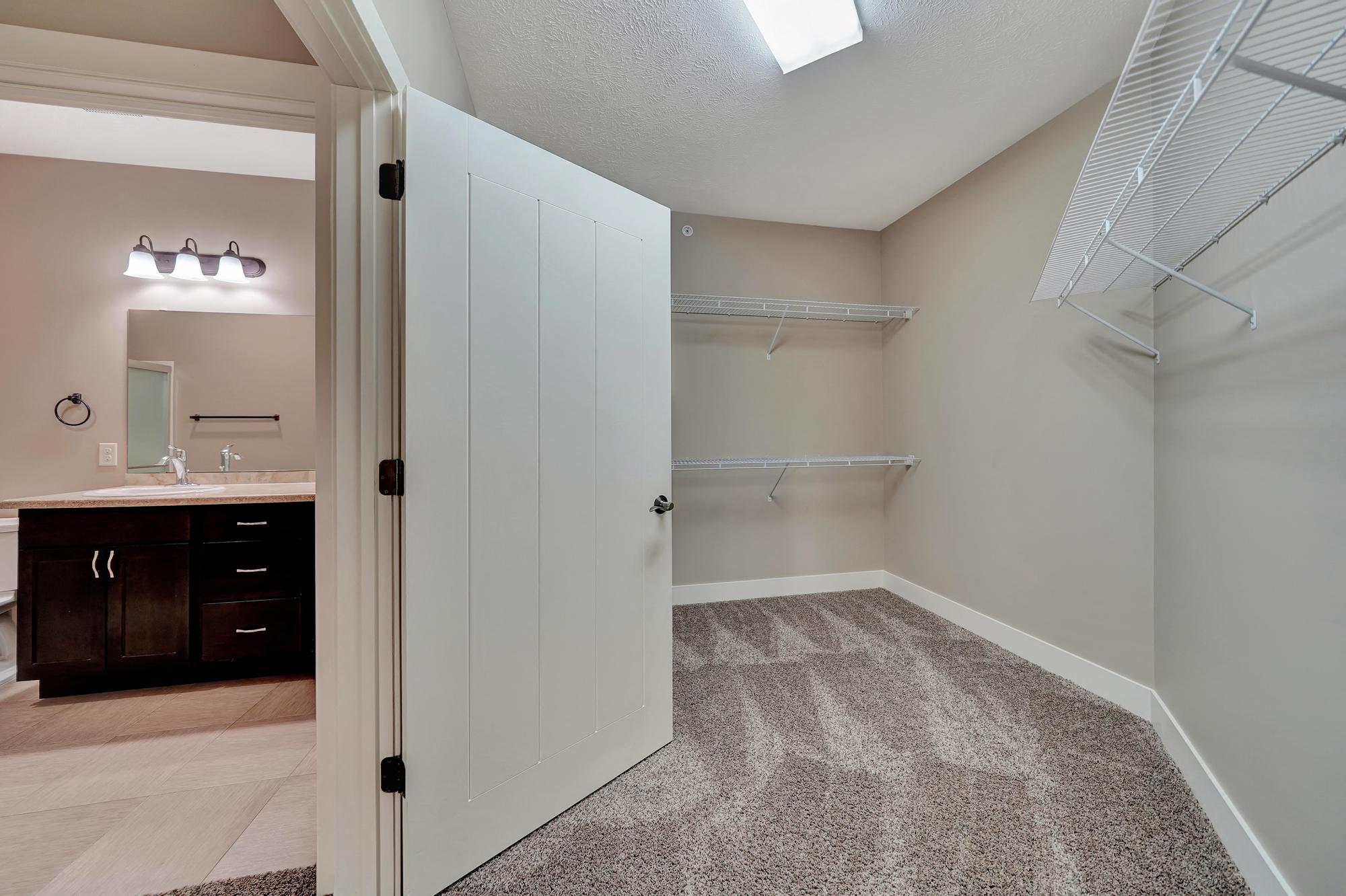 a bathroom with a closet and a sink and a mirror