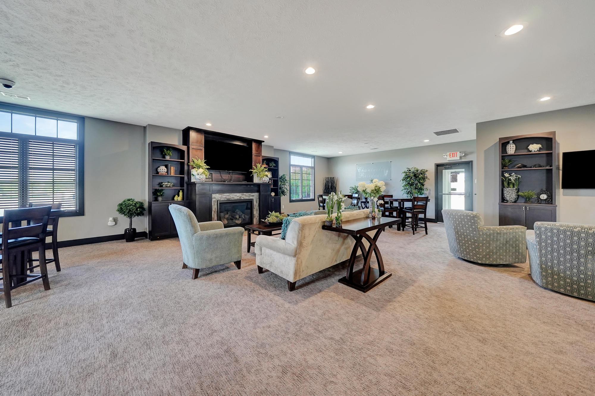 a living room with couches and chairs and a fireplace