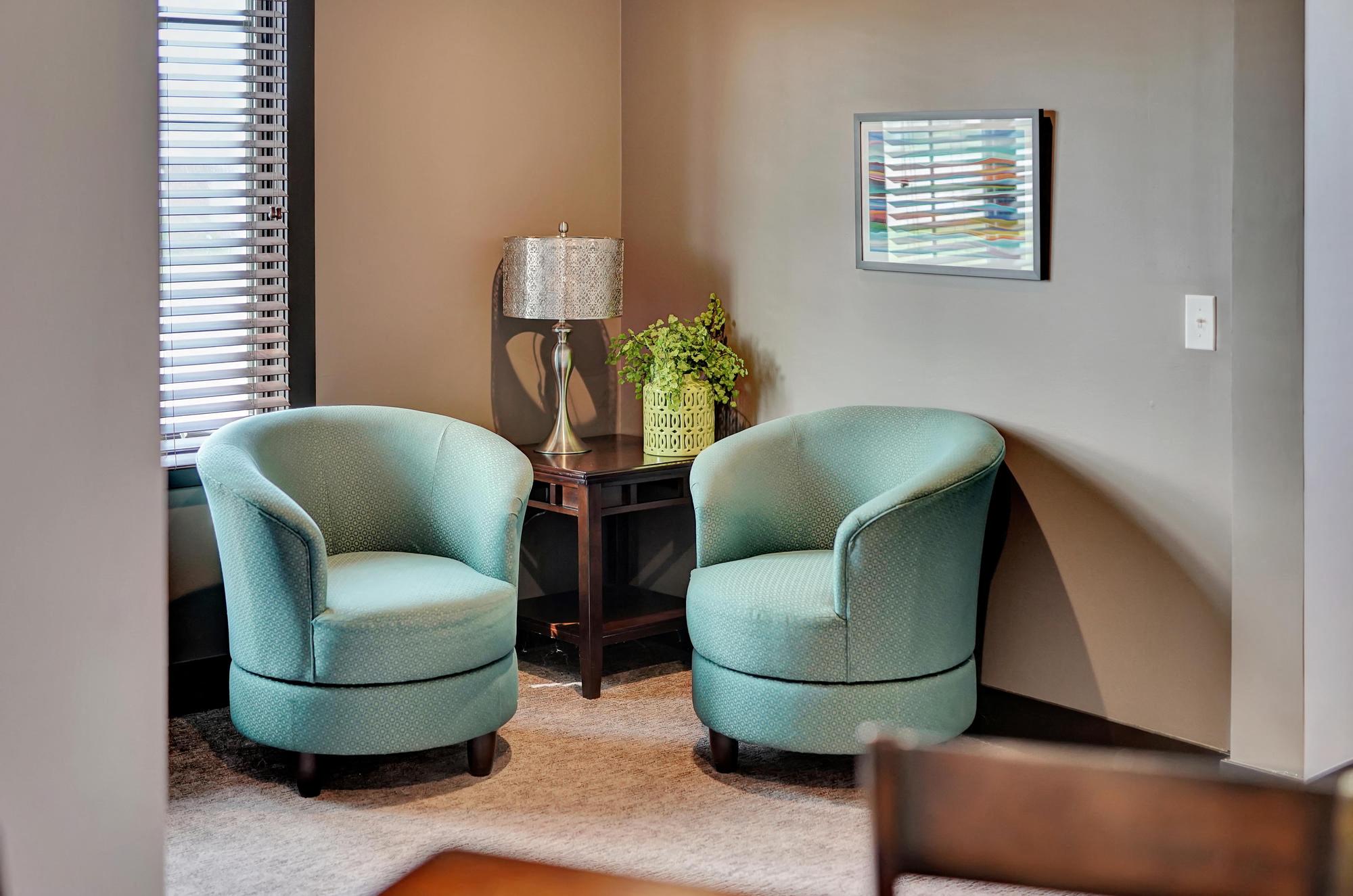 a living room with two blue chairs and a nook