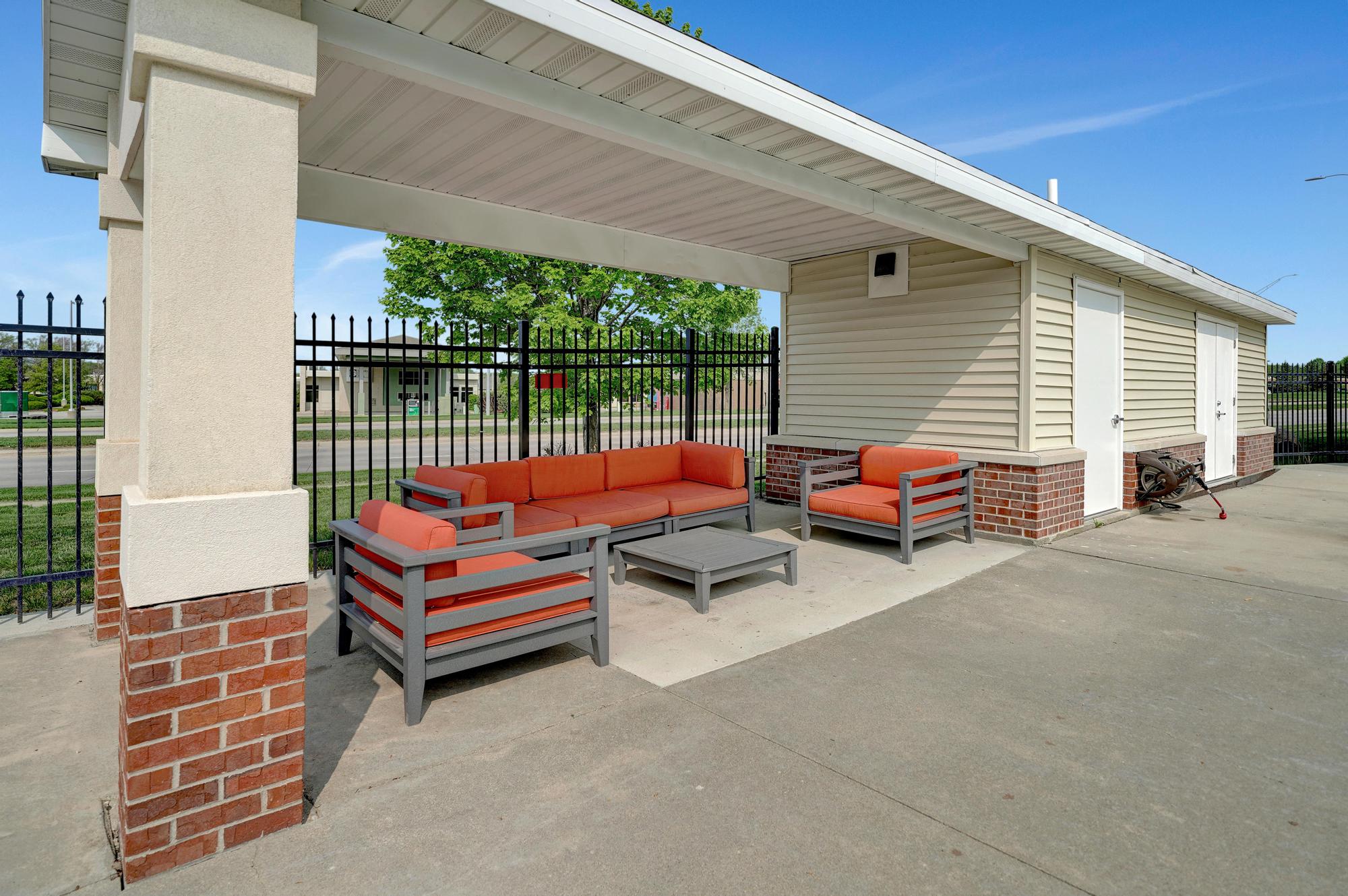our apartments have a patio with furniture and a black fence