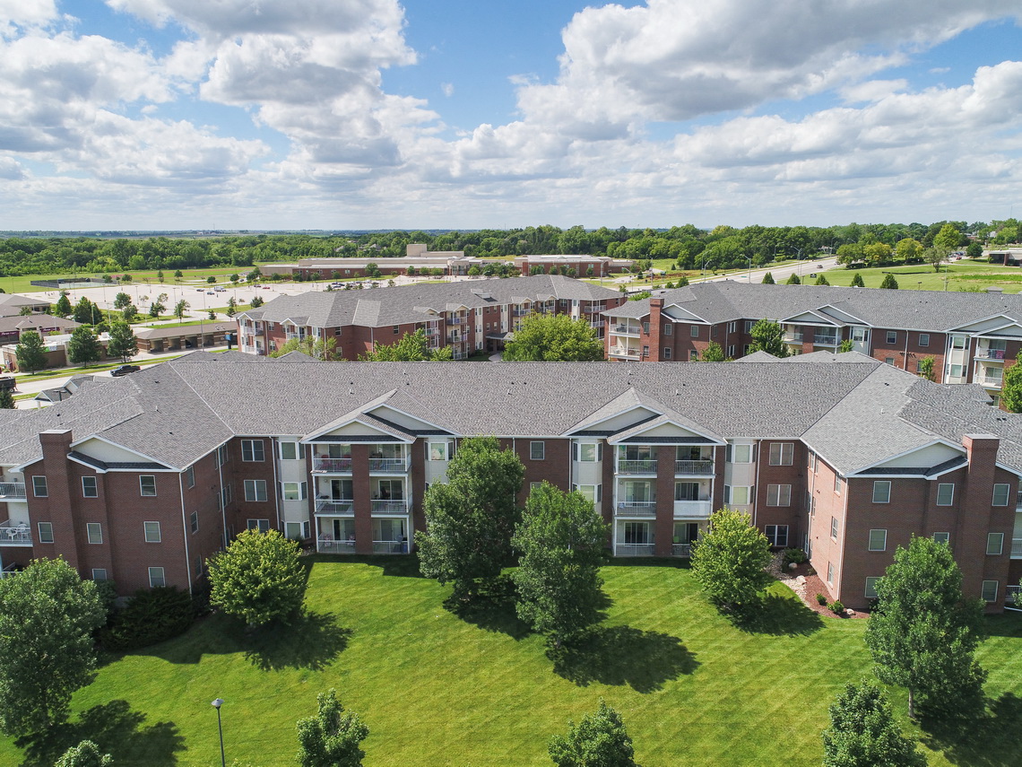 an aerial view of an apartment complex with green grass and trees