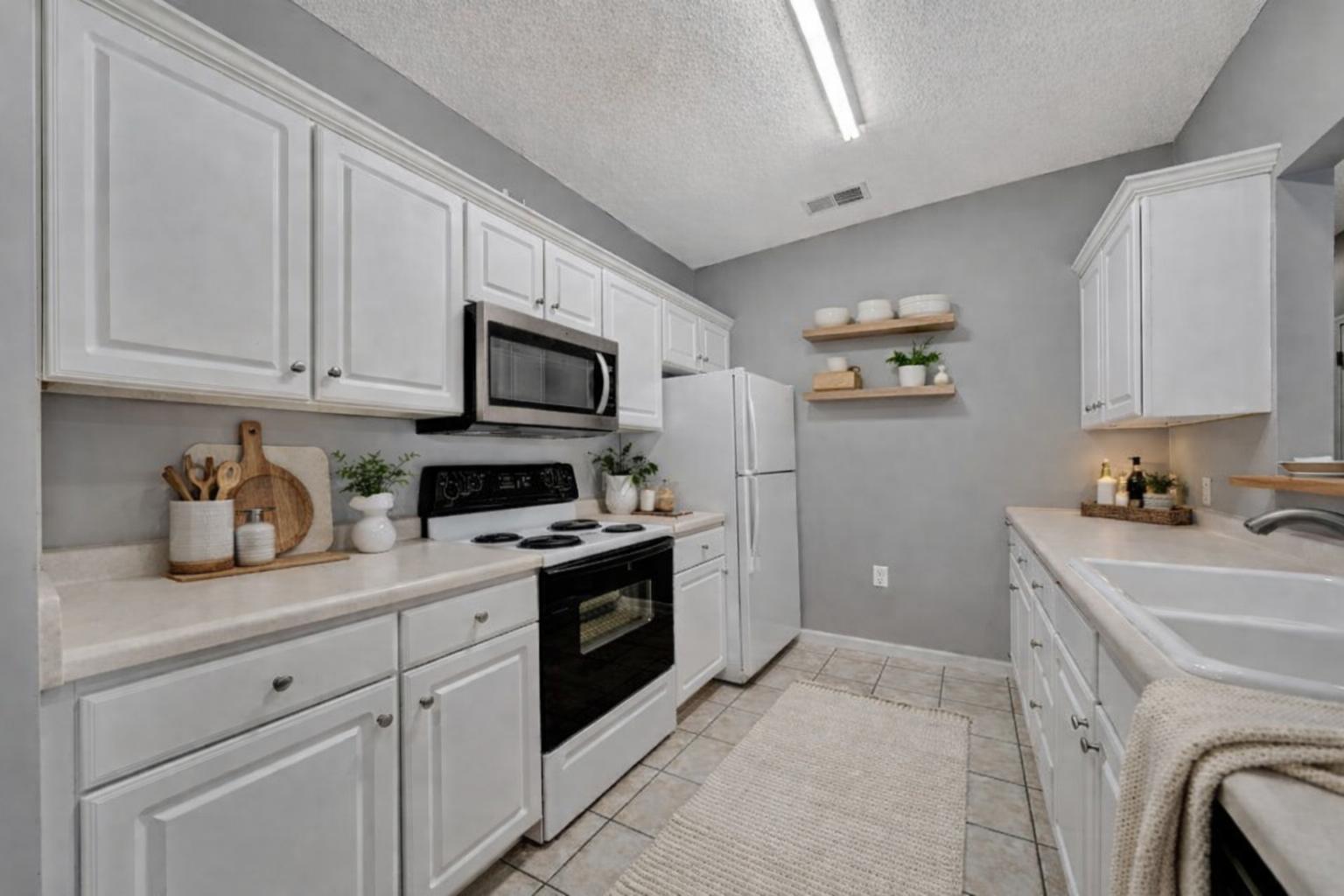 A kitchen with white cabinets and appliances.