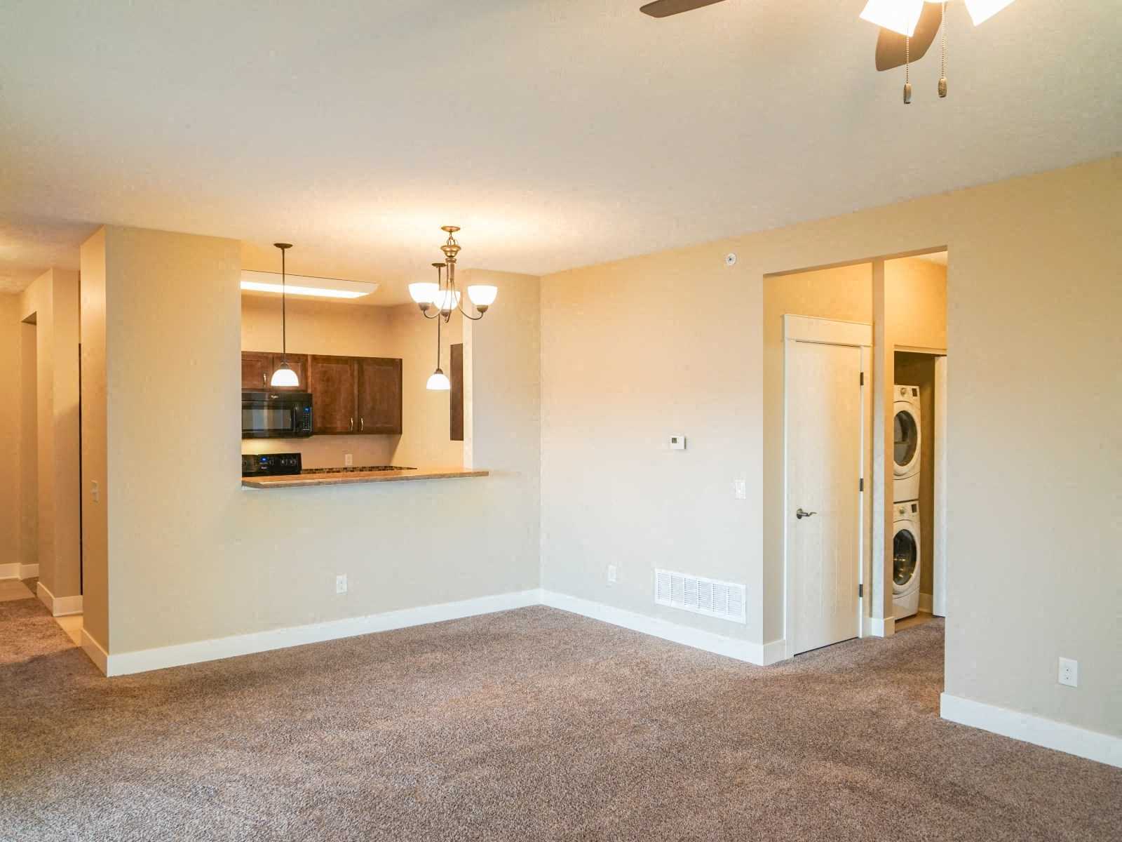 A spacious room with a washer and dryer in the doorway.