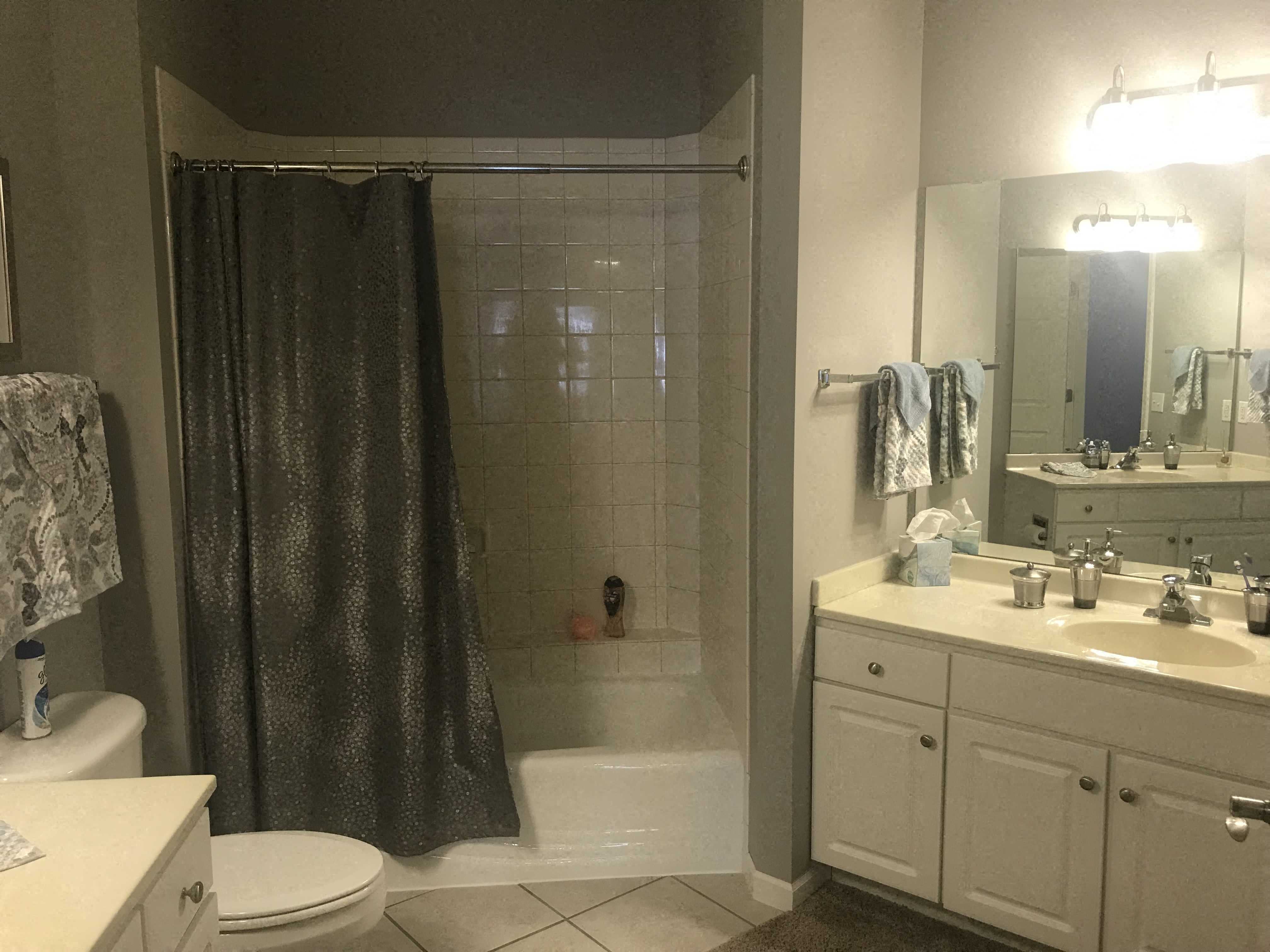 A bathroom with a toilet, sink, and shower.