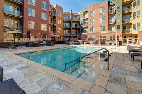 A swimming pool surrounded by apartment buildings.