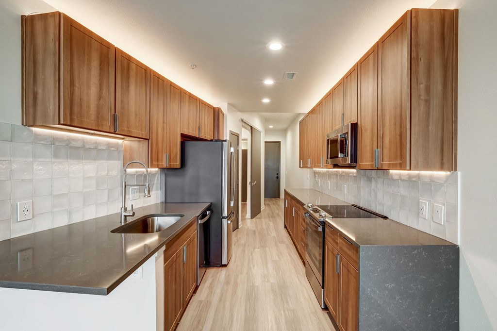 A modern kitchen with wooden cabinets and stainless steel appliances.