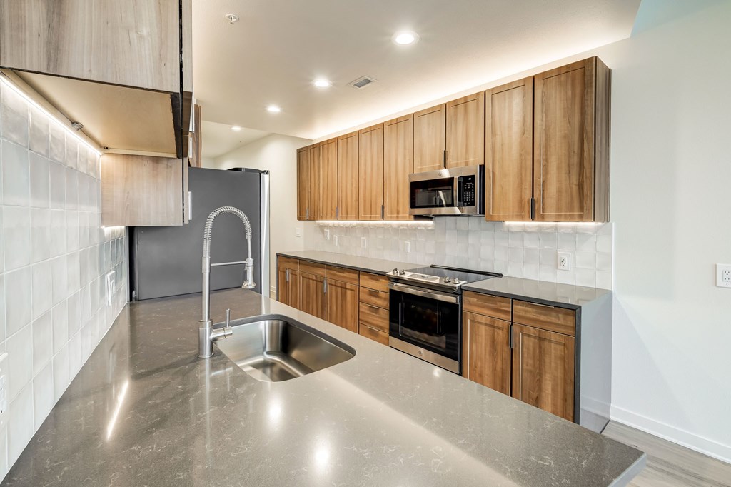 A modern kitchen with wooden cabinets and stainless steel appliances.