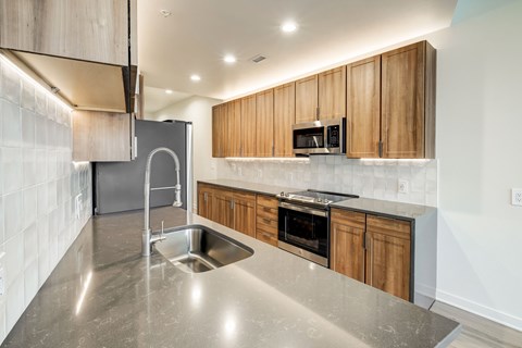 A modern kitchen with wooden cabinets and stainless steel appliances.