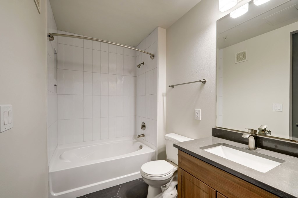 A white bathroom with a toilet, sink, and bathtub.