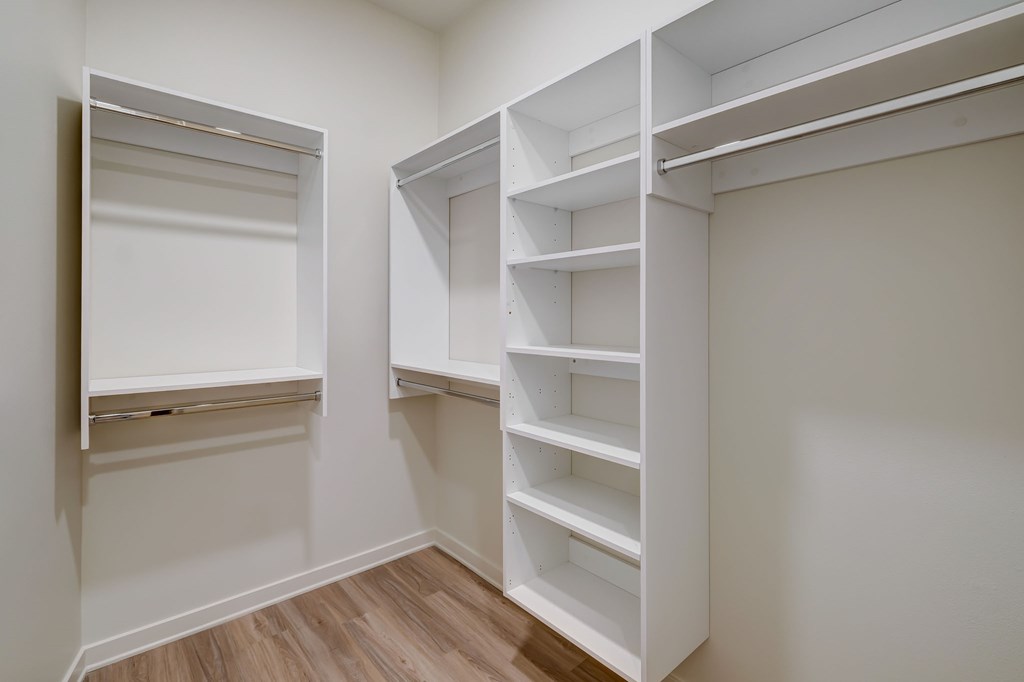 A white closet with shelves and a door.