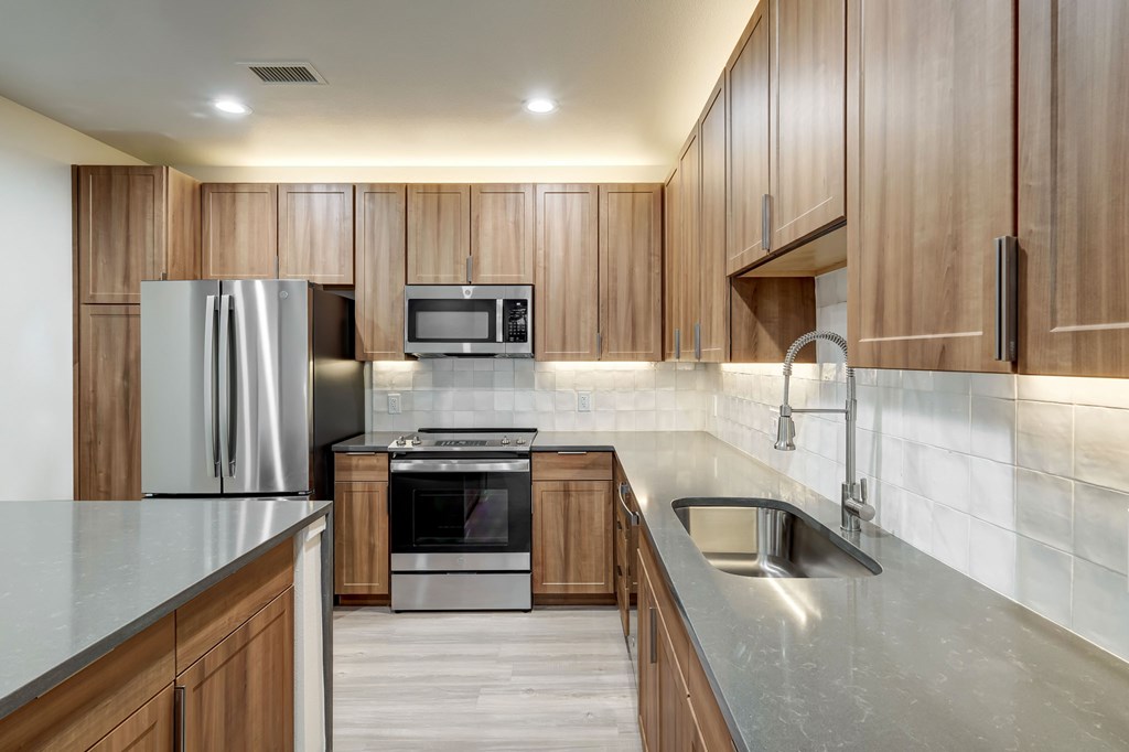 A modern kitchen with wooden cabinets and stainless steel appliances.