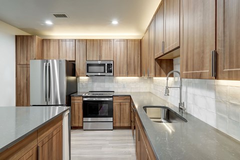 A modern kitchen with wooden cabinets and stainless steel appliances.