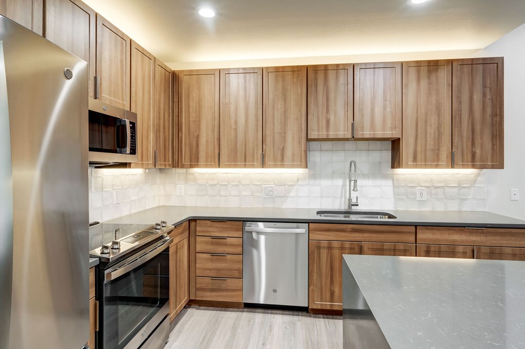 A modern kitchen with wooden cabinets and stainless steel appliances.