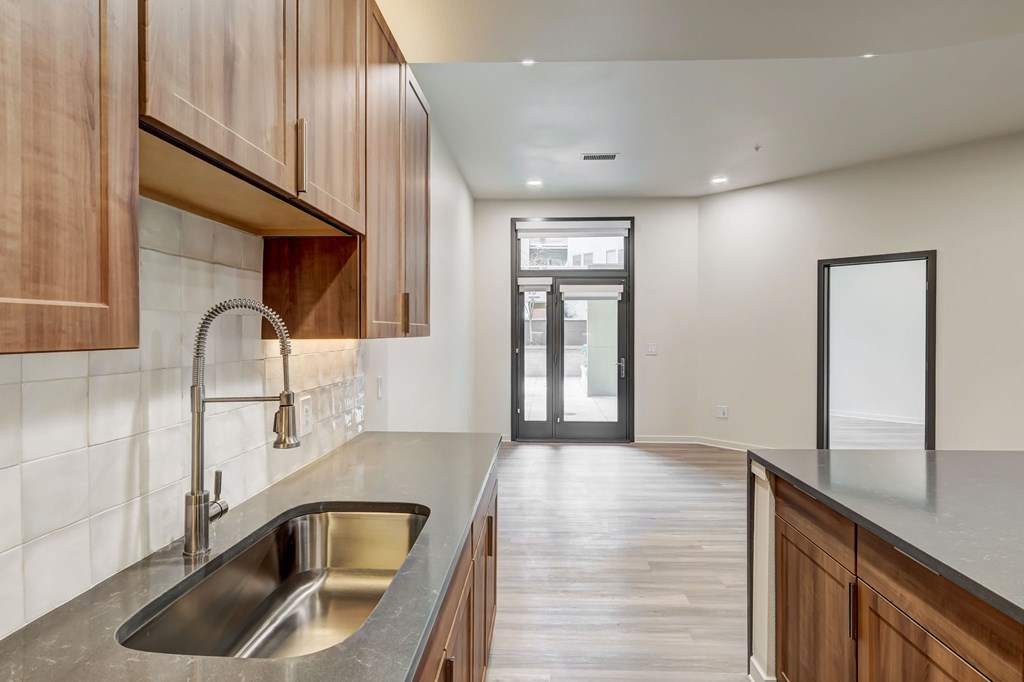 A modern kitchen with wooden cabinets and a stainless steel sink.