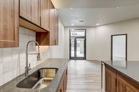A modern kitchen with wooden cabinets and a stainless steel sink.