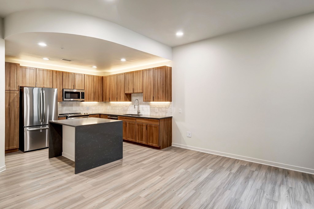 A kitchen with a refrigerator, microwave, and a countertop.