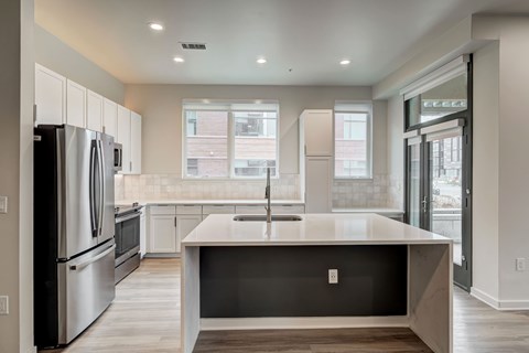 A modern kitchen with stainless steel appliances and a large island.
