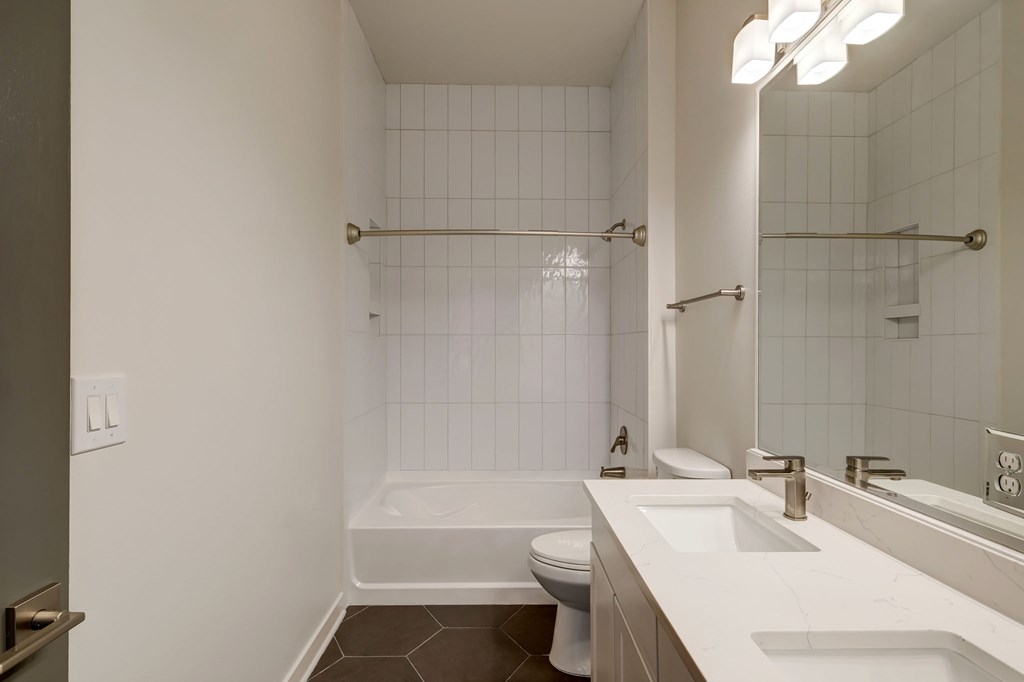 A white bathroom with a toilet, sink, and shower.