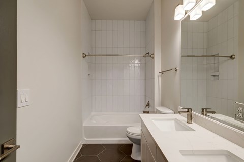 A white bathroom with a toilet, sink, and shower.