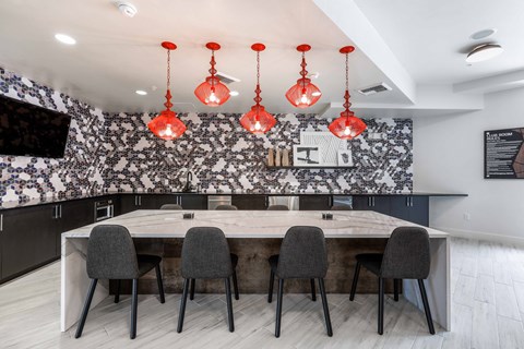 a kitchen with a long counter and chairs in front of a table
