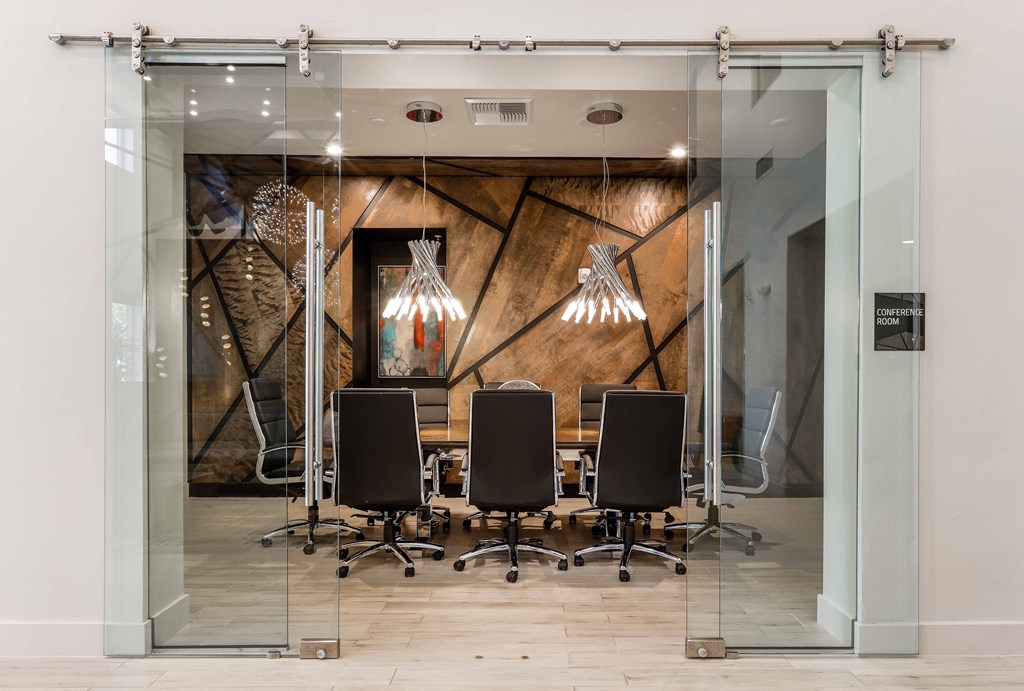 a conference room with glass doors and a table with chairs